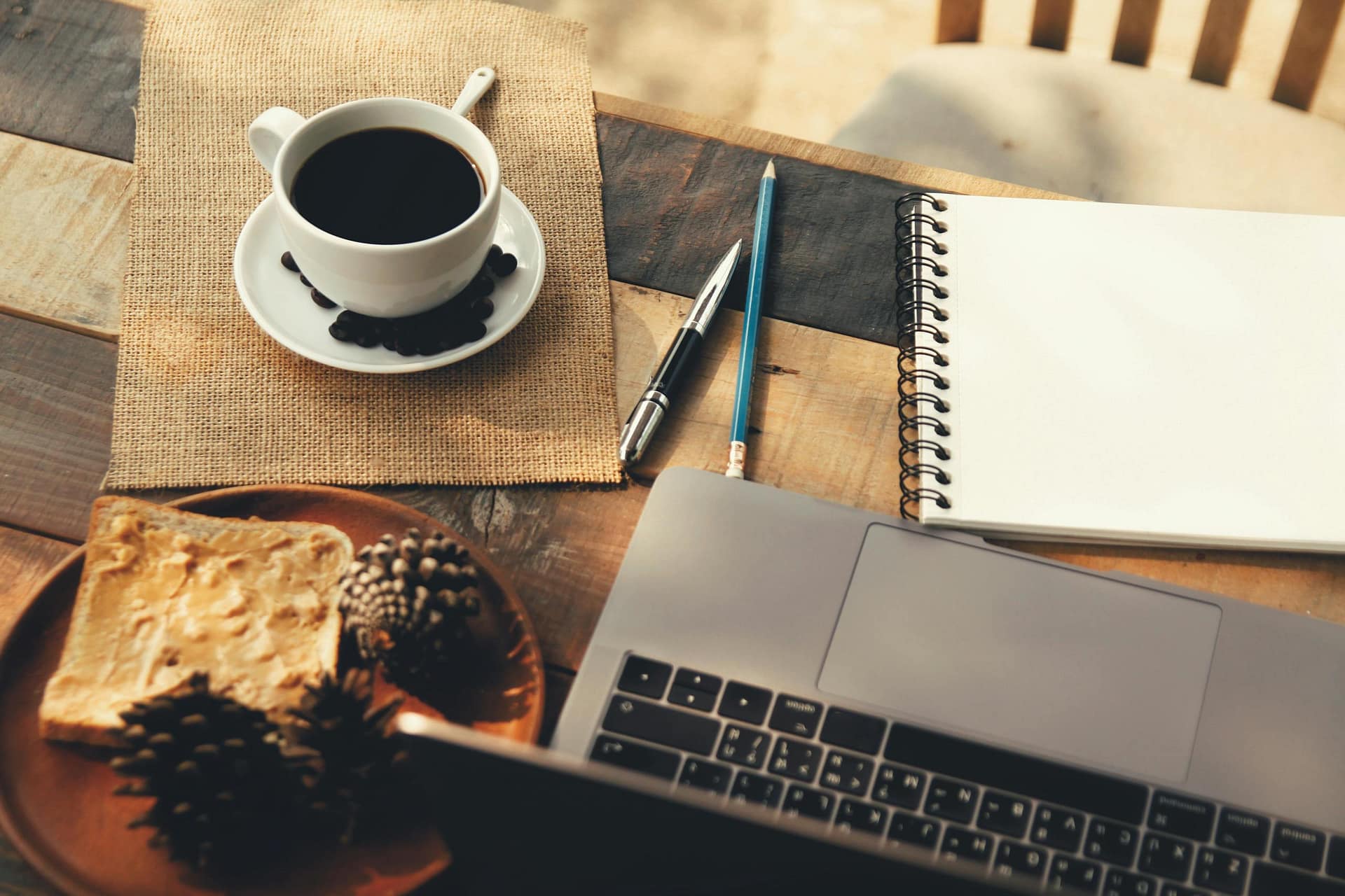 Laptop and notebook on table with coffee representing blogging ideas